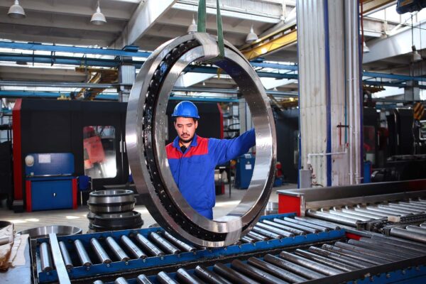 worker controls the transportation of a large diameter bearing